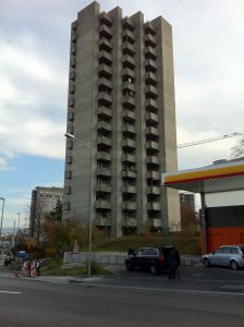 Photo de la Triemli Tower, ou Hochhaus am Triemliplatz, prise depuis la Birmensdorferstrasse à Zurich. Sur la droite, de la photo, on distigue un station Shell.