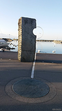 vue en perspective de la girouette éole du port d'Ouchy à Lausanne avec un des 4 monolithes 